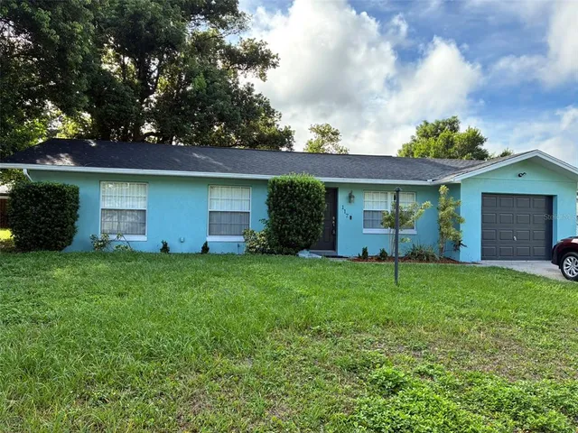 a front view of house with a garden
