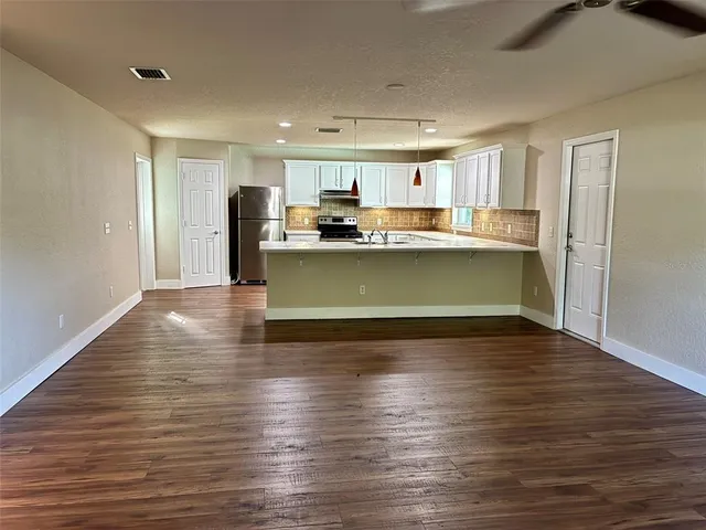 a view of kitchen with cabinets and wooden floor