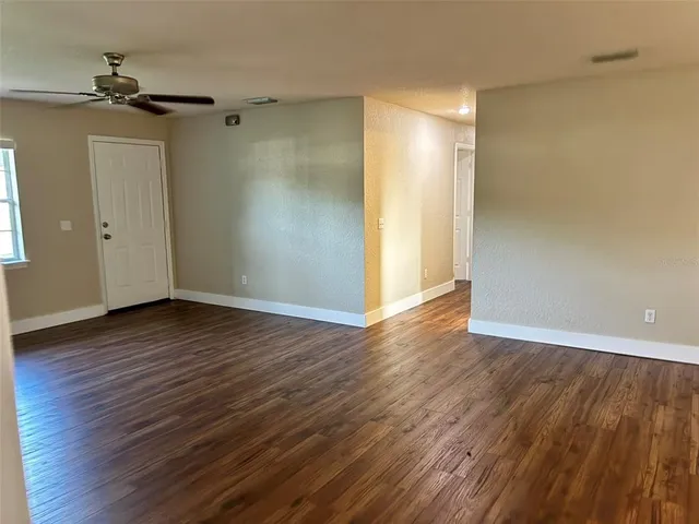 a view of an empty room with wooden floor