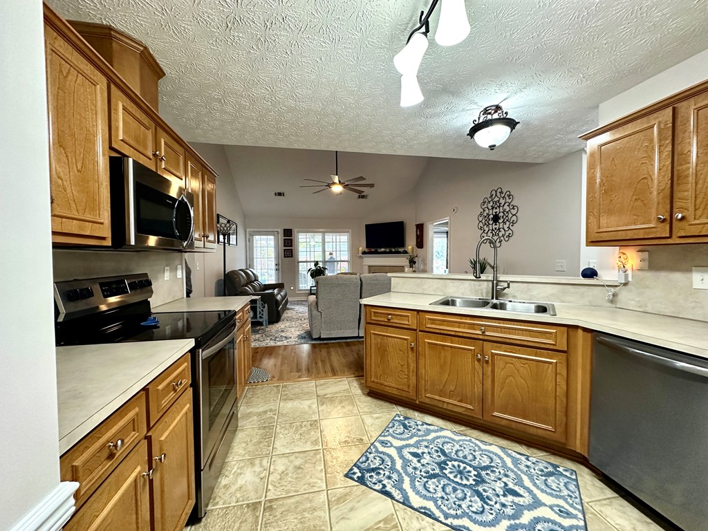 8013 Silverado Drive Columbus, GA 31909 - Photo 11 of 47 a kitchen with stainless steel appliances granite countertop a sink a stove top oven a chimney cabinets and a dining table