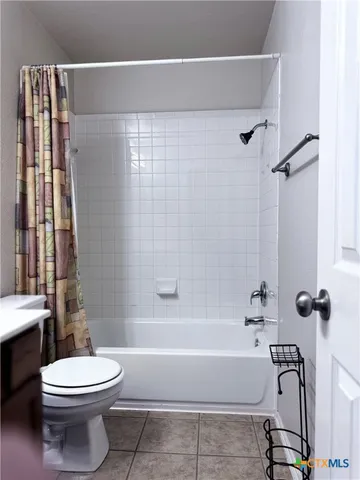 a bathroom with a white toilet and a bathtub