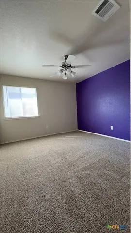 an empty room with a ceiling fan and window