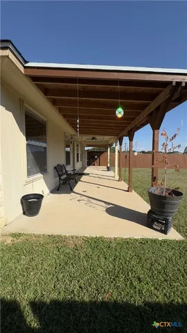 a view of a patio with a table and chairs under an umbrella