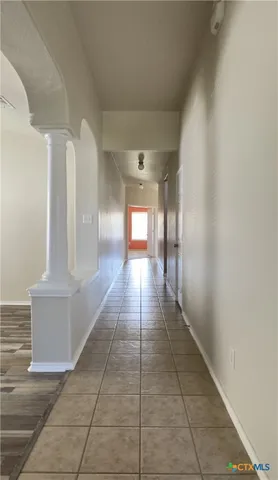 a hallway with beautiful frames and flower plants