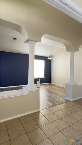 a view of a livingroom with an empty space and a window