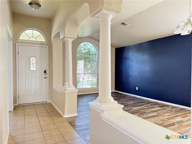 a view of a livingroom with a large window and wooden floor