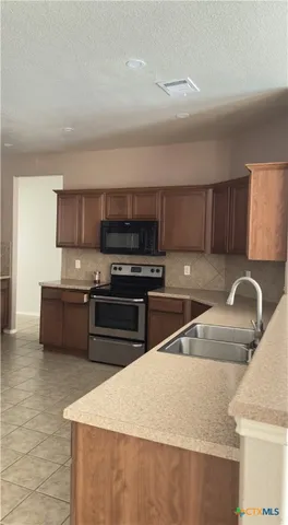 a kitchen with stainless steel appliances granite countertop a sink and a stove