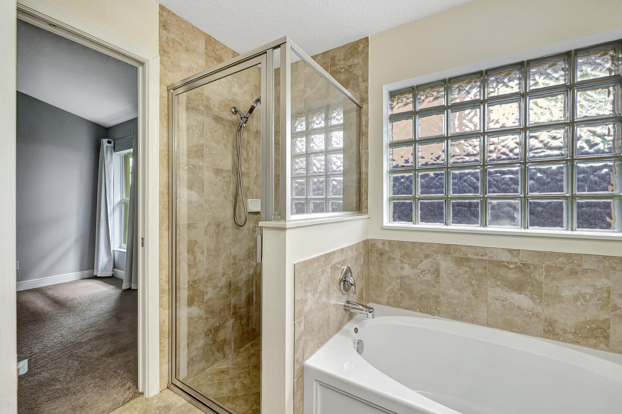9331 Breakers Row Fort Pierce, FL 34945 - Photo 20 of 39 a bathroom with a bathtub and a shower