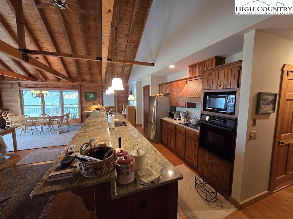 979 Wagon Road Warrensville, NC 28693 - Photo 18 of 50 a kitchen with stainless steel appliances granite countertop a stove refrigerator and cabinets