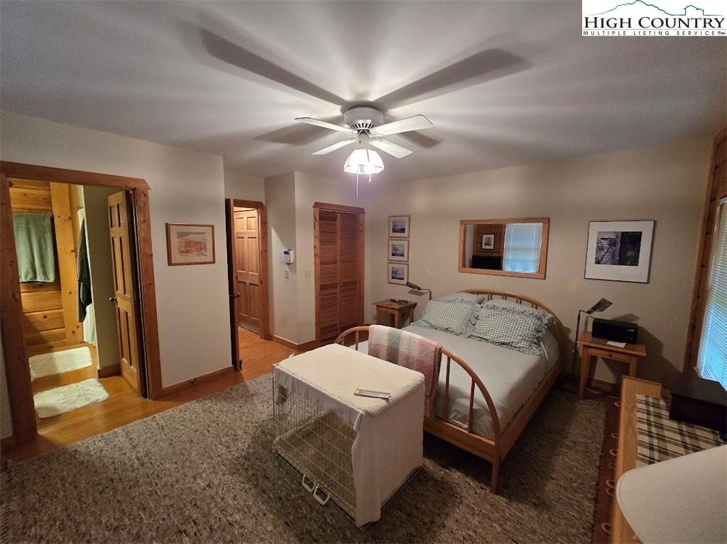 979 Wagon Road Warrensville, NC 28693 - Photo 21 of 50 a bedroom with a bed and a chandelier