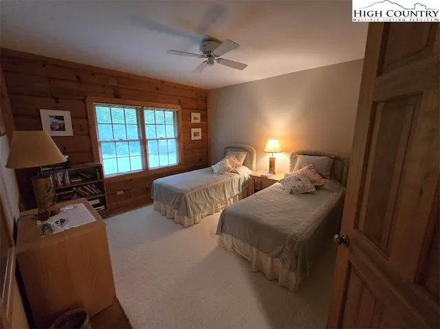 a bedroom with two beds and a desk