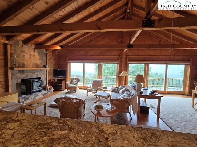 a living room with furniture a fireplace and a floor to ceiling window