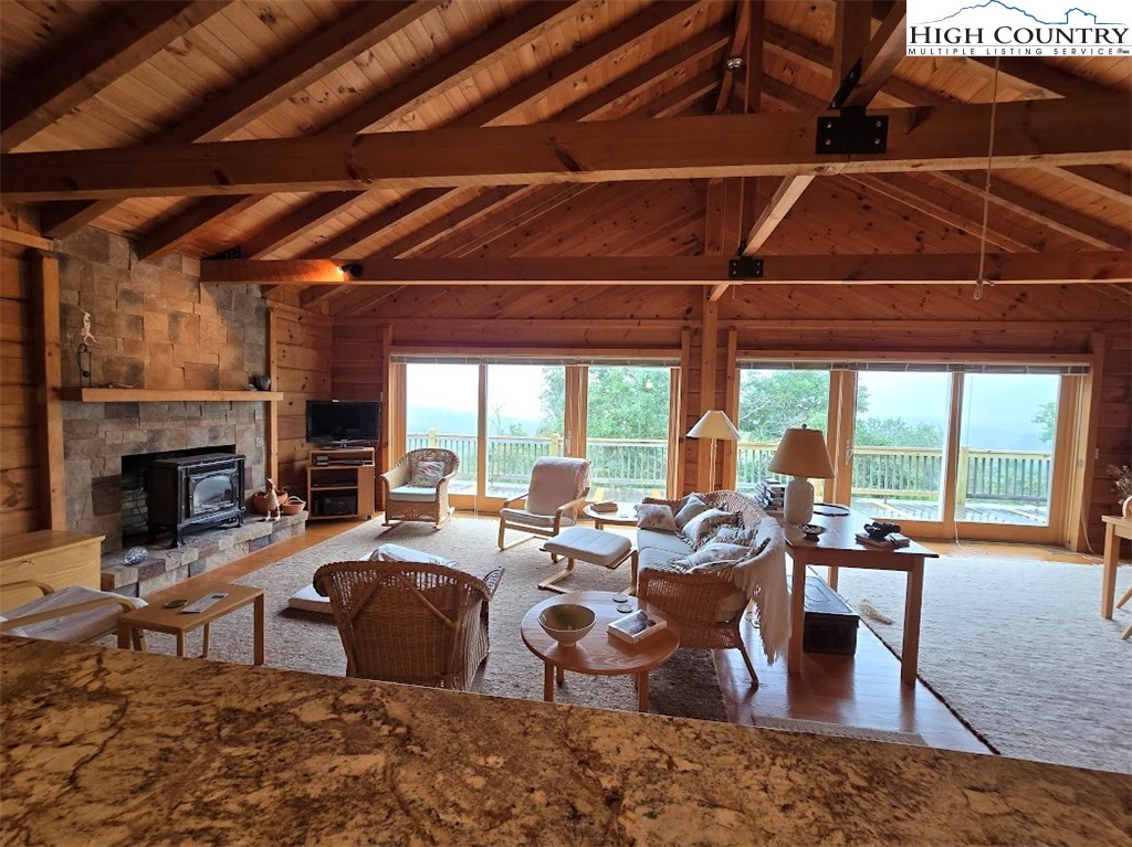 979 Wagon Road Warrensville, NC 28693 - Photo 35 of 50 a living room with furniture a fireplace and a floor to ceiling window