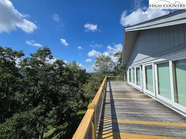 a view of a balcony with wooden floor and fence