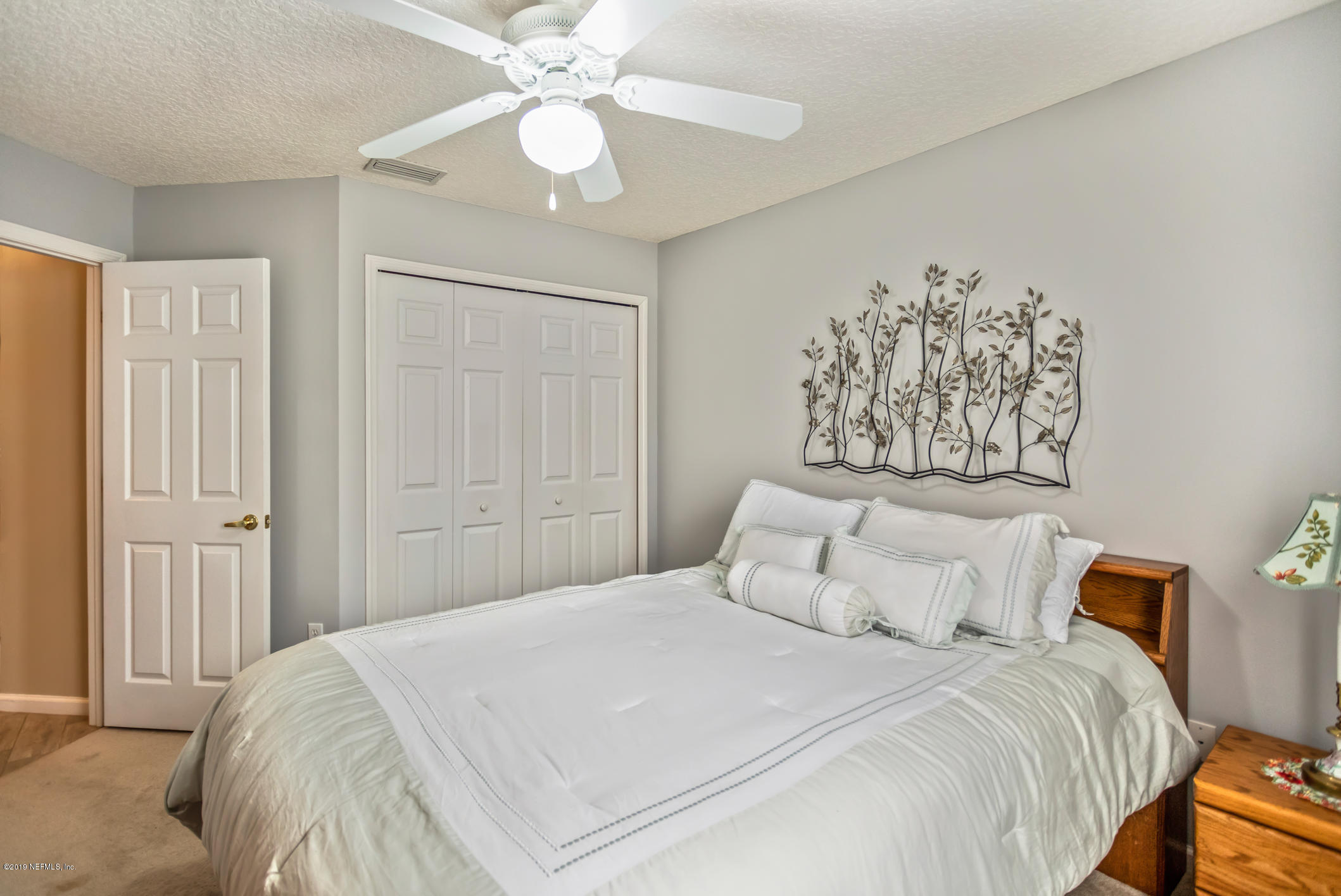 1764 Keswick Road St. Augustine, FL 32084 - Photo 13 of 20 a bedroom with a large bed and a chandelier