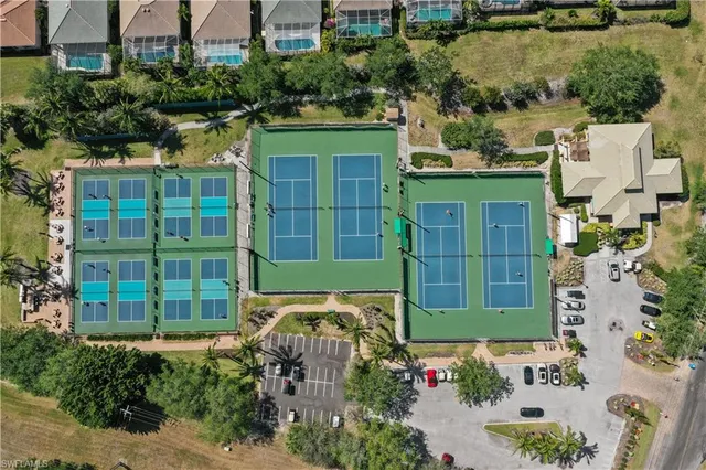 a view of a tennis ground with large trees