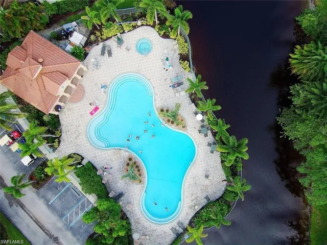 an aerial view of a house with swimming pool and outdoor seating