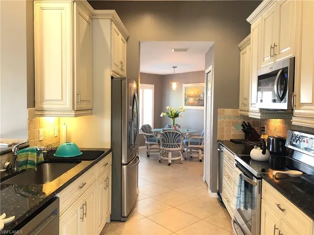 a kitchen with stainless steel appliances granite countertop sink stove and refrigerator