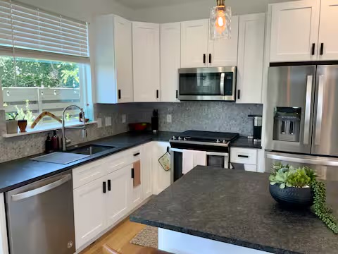 6100 Ponca Street, Unit 2 Austin, TX 78741 - Photo 8 of 17 a kitchen with stainless steel appliances granite countertop a stove a sink and a microwave
