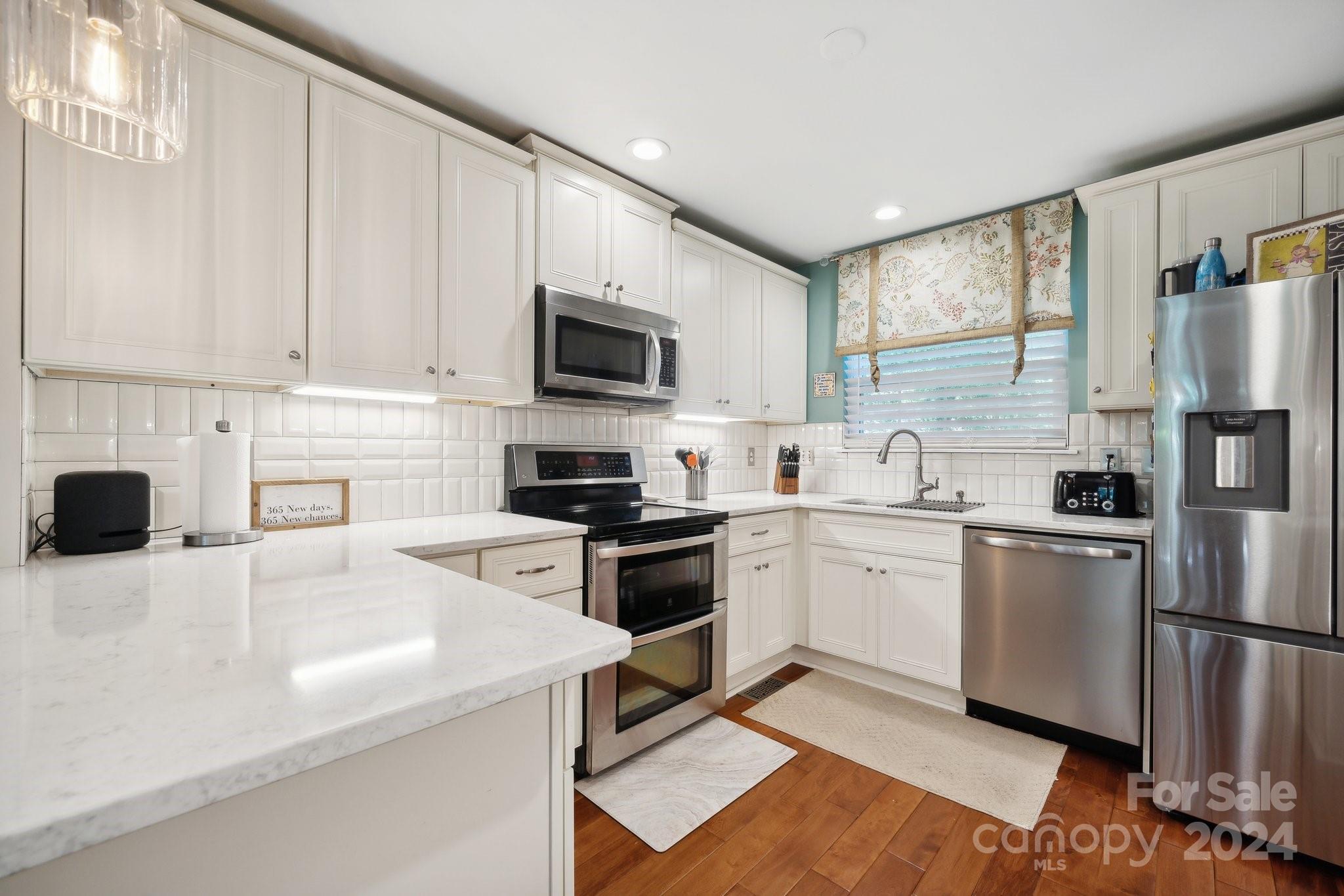 9012 St Thomas Lane Charlotte, NC 28277 - Photo 8 of 25 a kitchen with white cabinets and stainless steel appliances