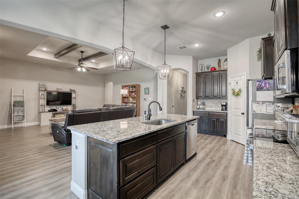 211 Rees Avenue Godley, TX 76044 - Photo 6 of 18 a kitchen with stainless steel appliances granite countertop a sink a stove and a wooden floors
