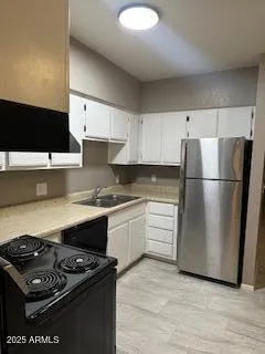 a kitchen with a stove a refrigerator and a sink