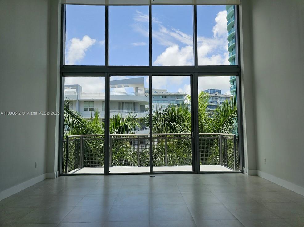 6000 Collins Avenue, Unit 528 Miami Beach, FL 33140 - Photo 1 of 26 a view of an empty room with wooden floor and windows