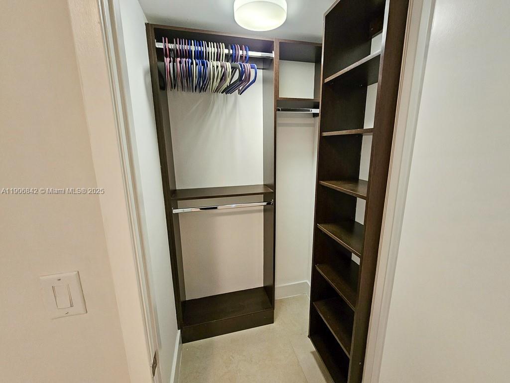 6000 Collins Avenue, Unit 528 Miami Beach, FL 33140 - Photo 12 of 26 a view of walk in closet with clothes and shoes