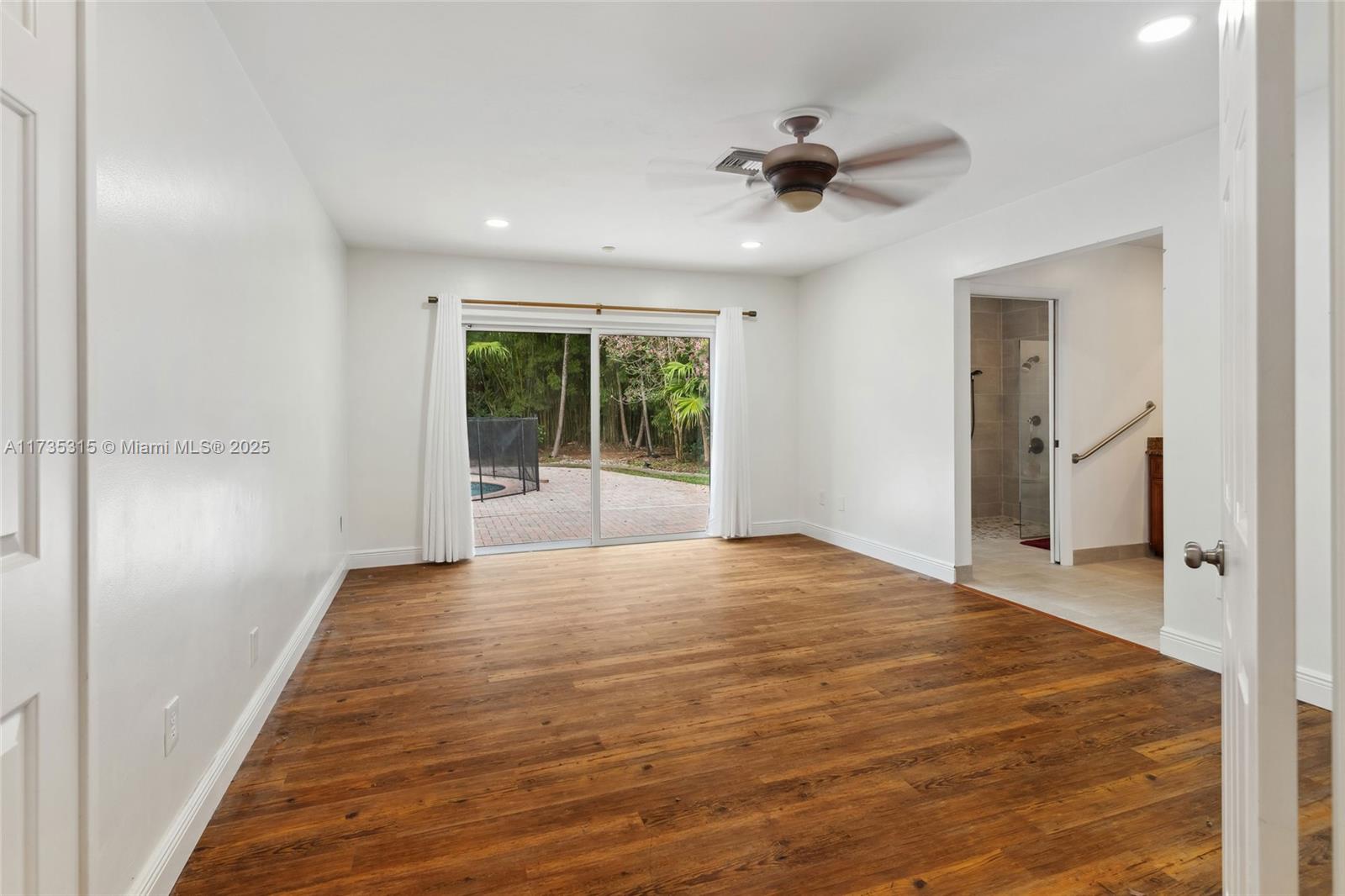 11601 Island Road Cooper City, FL 33026 - Photo 17 of 35 a view of an empty room with wooden floor and a window