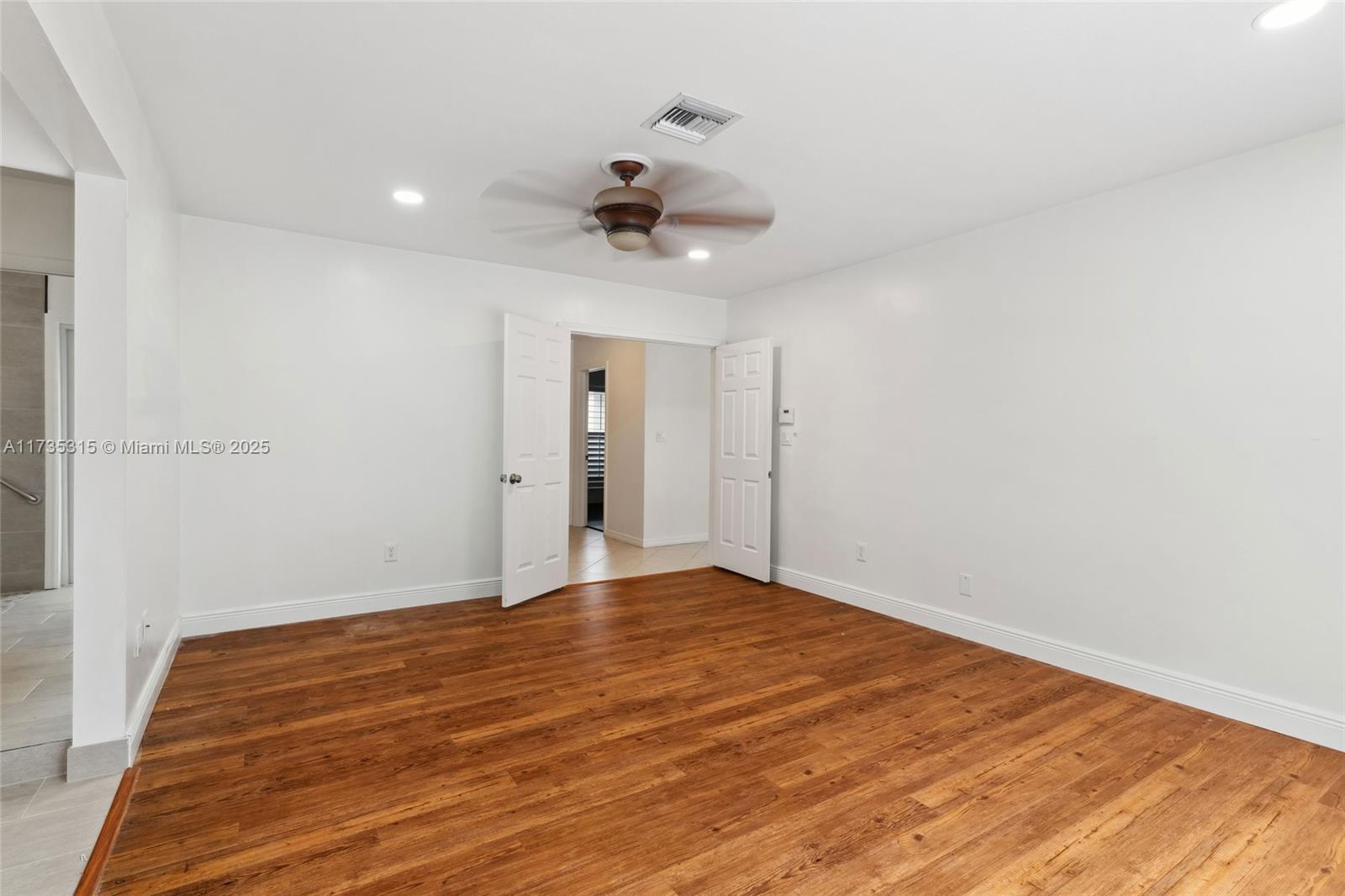 11601 Island Road Cooper City, FL 33026 - Photo 19 of 35 a view of empty room with wooden floor and fan