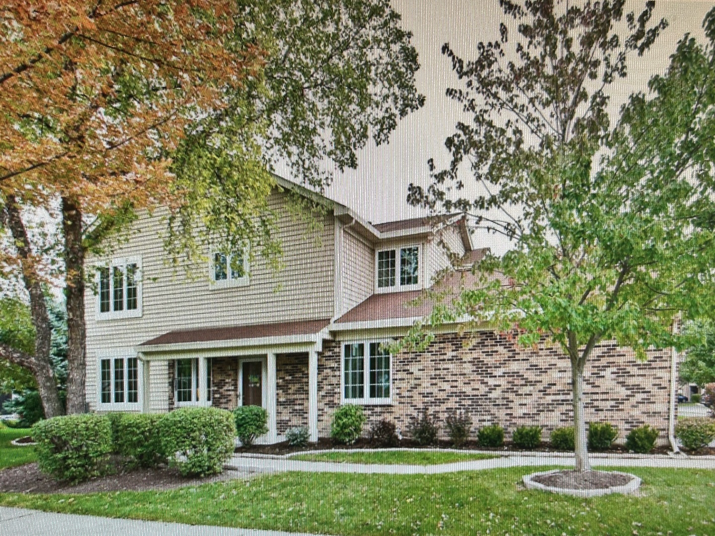 a front view of a house with a garden and trees