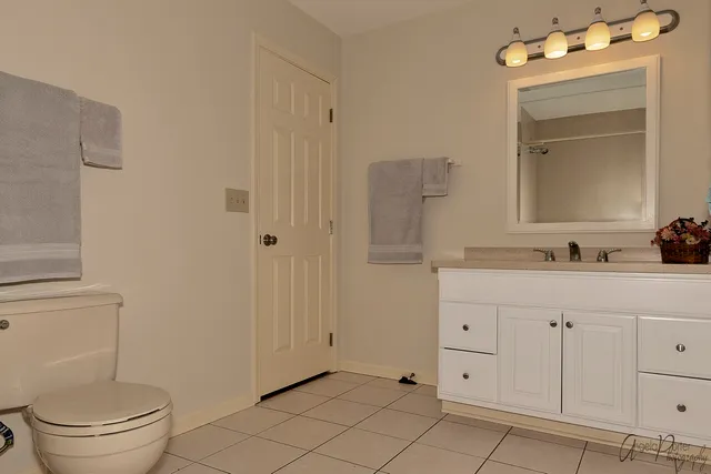 a bathroom with a sink vanity mirror and toilet