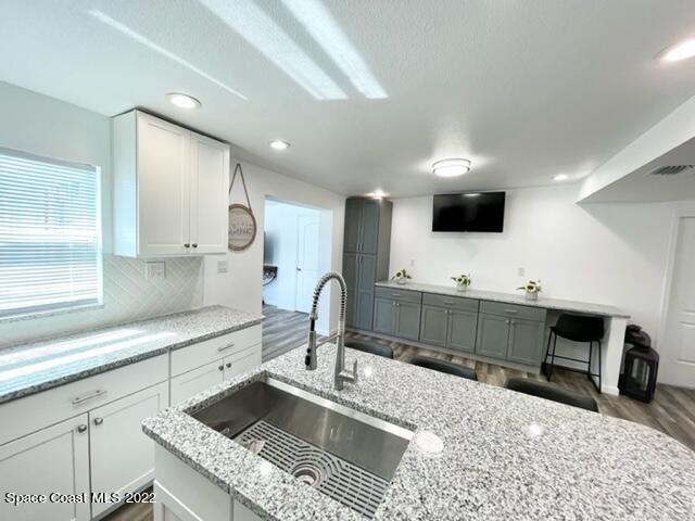 2855 Diamond Road Titusville, FL 32796 - Photo 22 of 61 a kitchen with stainless steel appliances kitchen island granite countertop a sink and a stove top oven with wooden floor