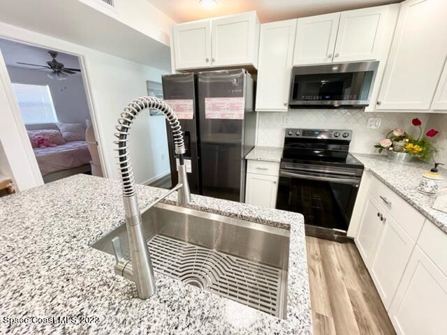 2855 Diamond Road Titusville, FL 32796 - Photo 23 of 61 a kitchen with stainless steel appliances kitchen island granite countertop a refrigerator and a stove top oven
