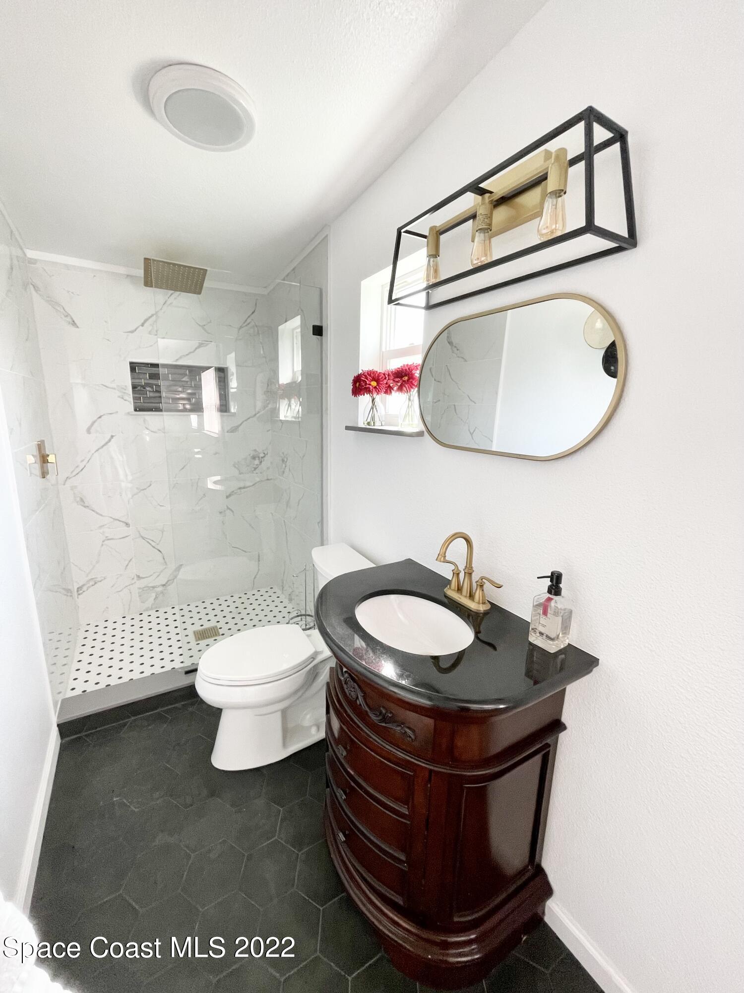 2855 Diamond Road Titusville, FL 32796 - Photo 40 of 61 a bathroom with a toilet a sink and a mirror