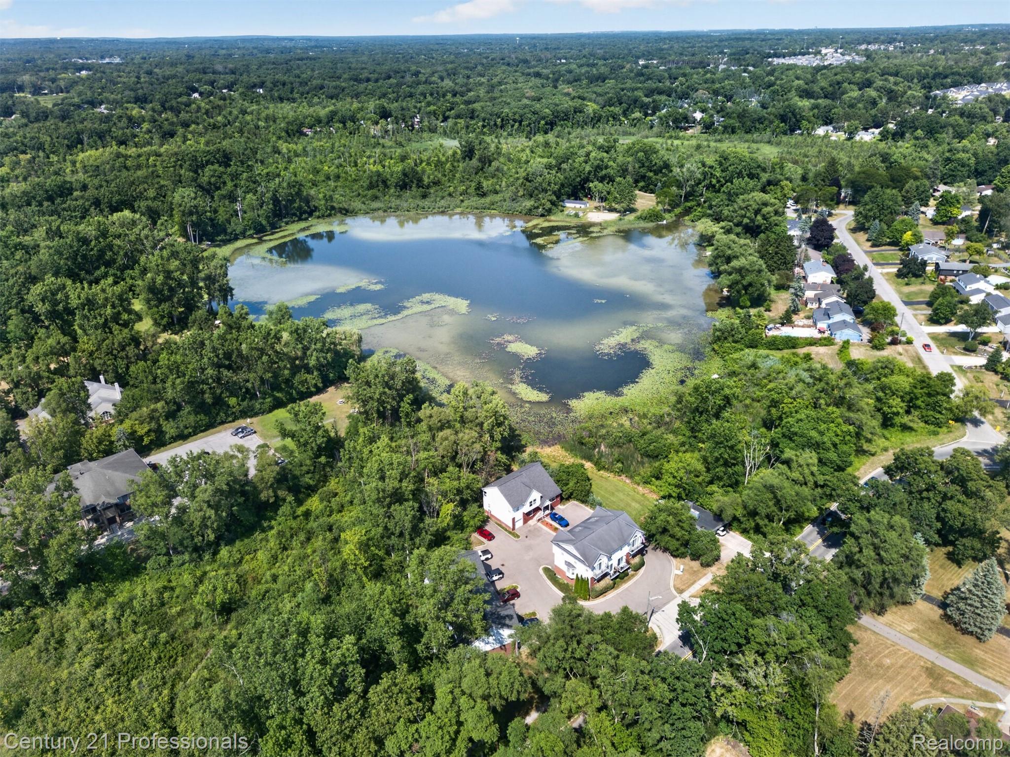 2042 Decker Road Walled Lake, MI 48390 - Photo 45 of 48 Hawk Lake Aerial perspective showcasing a serene lake surrounded by extensive mature trees