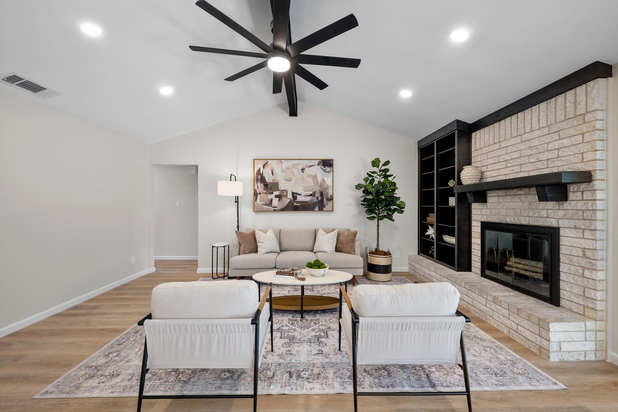 109 Woodland Road Georgetown, TX 78628 - Photo 19 of 40 A vaulted ceiling enhances this living room's generous fireplace and built-in shelving.