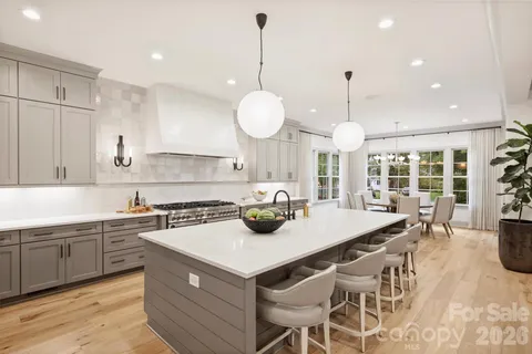 a kitchen with a stove a kitchen island a sink and a wooden cabinets