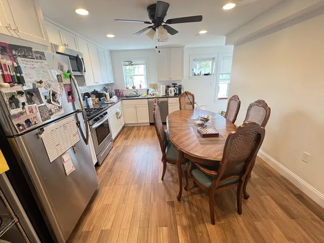 a view of a dining room with furniture and a kitchen view