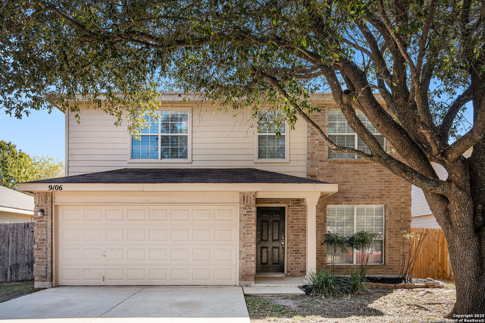 a front view of a house with a tree