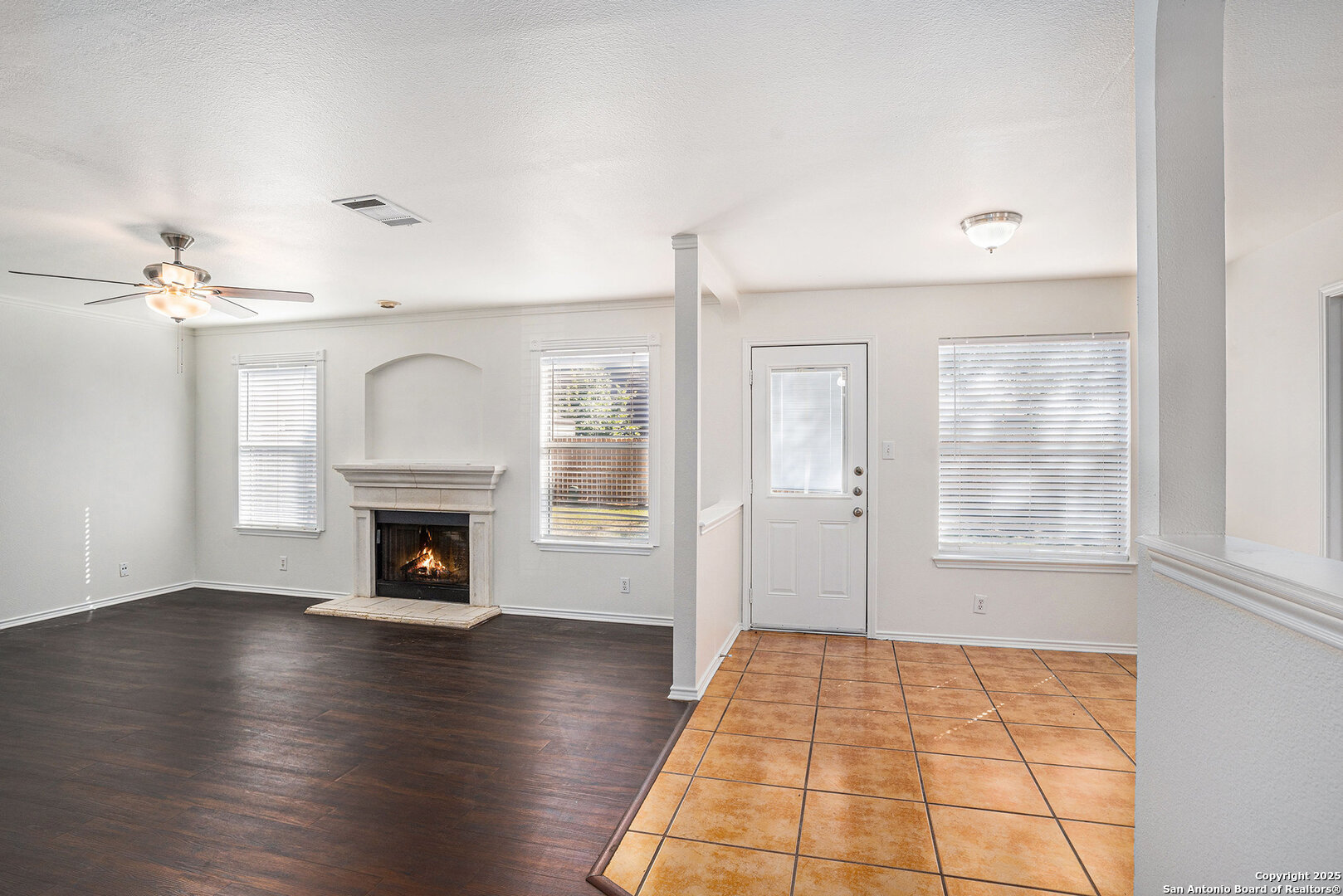 9106 Valhalla Selma, TX 78154 - Photo 4 of 17 an empty room with wooden floor fireplace and windows