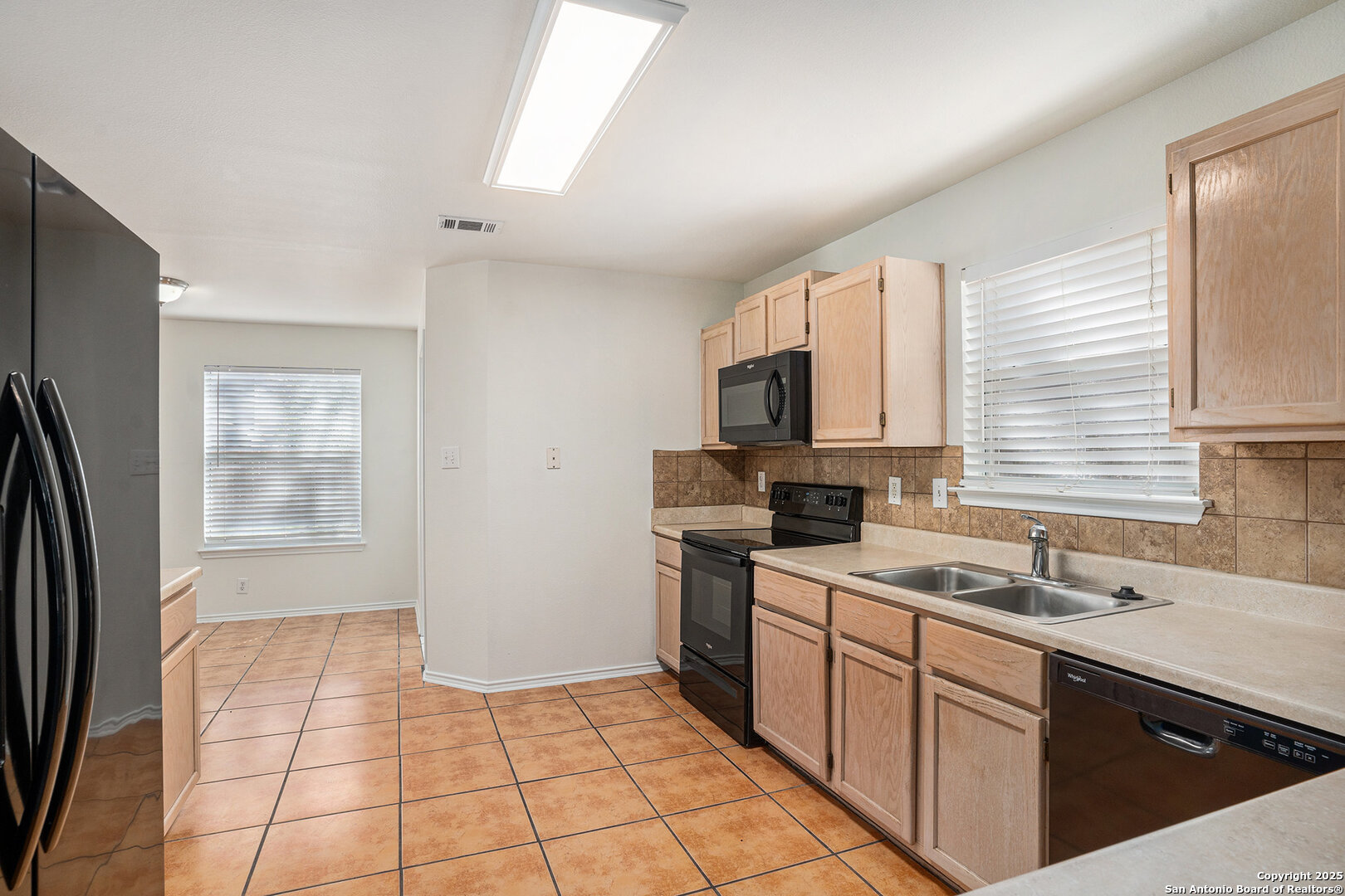 9106 Valhalla Selma, TX 78154 - Photo 8 of 17 a kitchen with a sink a refrigerator and cabinets