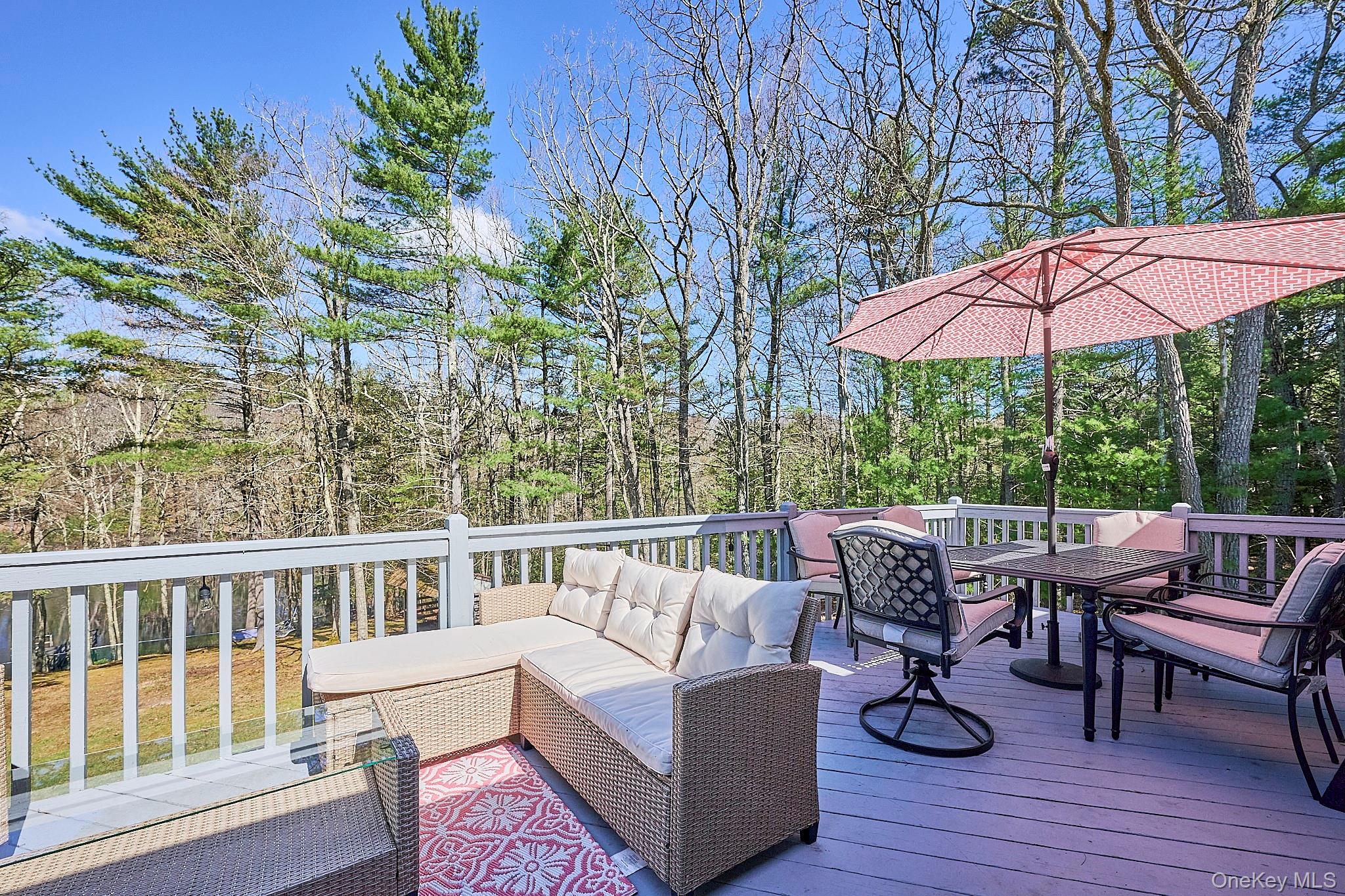 39 Pitio Road Glen Spey, NY 12737 - Photo 18 of 50 a view of a patio with couches table and chairs under an umbrella with wooden floor