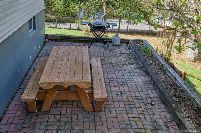 a kitchen with kitchen island a dining table chairs stainless steel appliances and windows