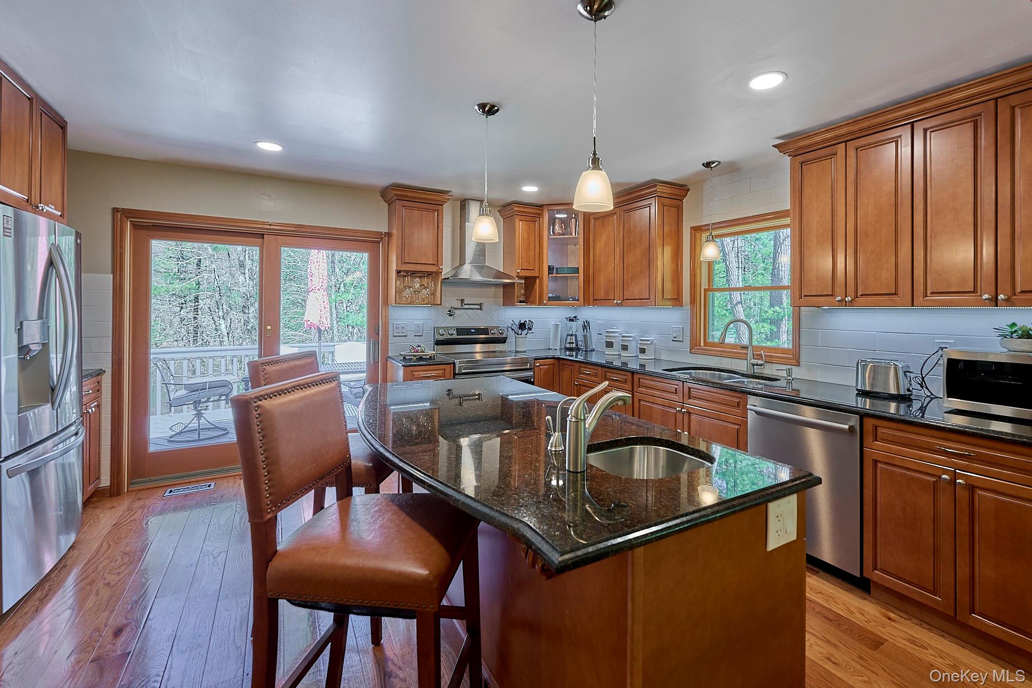 39 Pitio Road Glen Spey, NY 12737 - Photo 21 of 50 a kitchen with kitchen island a dining table chairs stainless steel appliances and windows