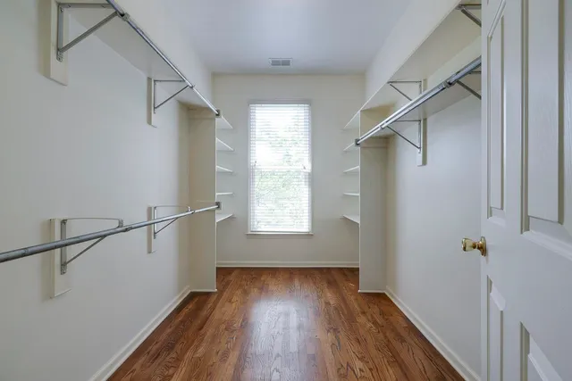 a view of hallway with a large window and wooden floor