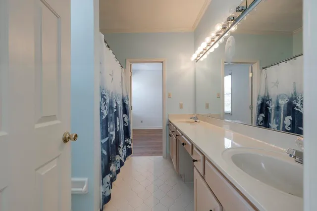 a spacious bathroom with a double vanity sink a large mirror and shower
