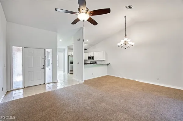 a view of a kitchen with a sink a refrigerator and a chandelier fan