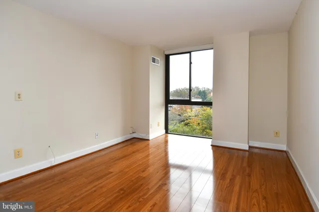 a view of an empty room with wooden floor