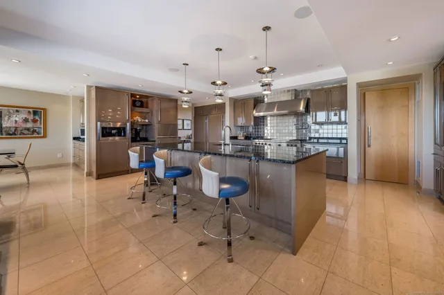 a kitchen with stainless steel appliances kitchen island granite countertop a table and chairs in it